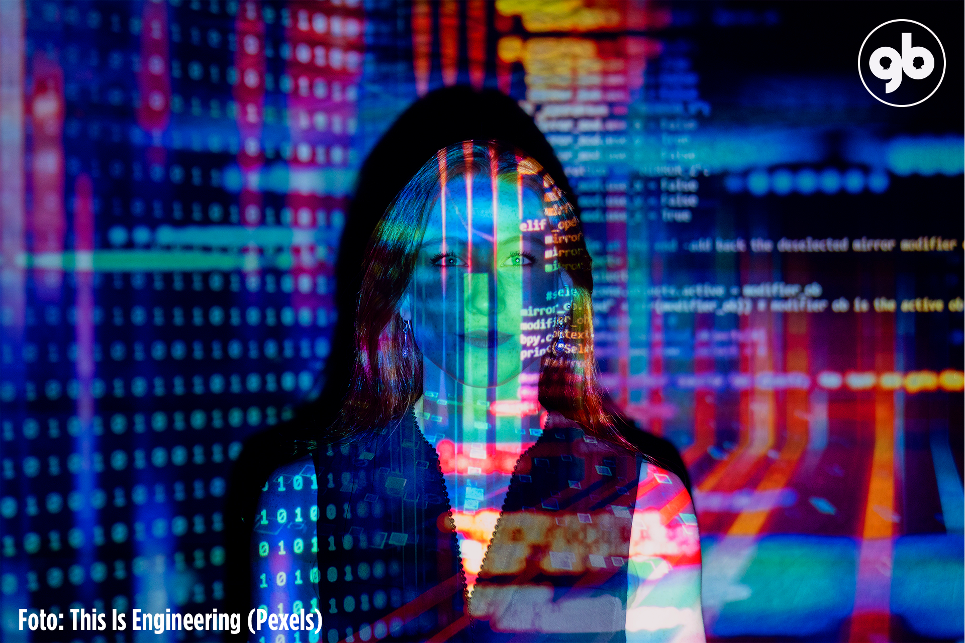 códigos de computação coloridos projetados sobre uma mulher branca encostada numa parede 